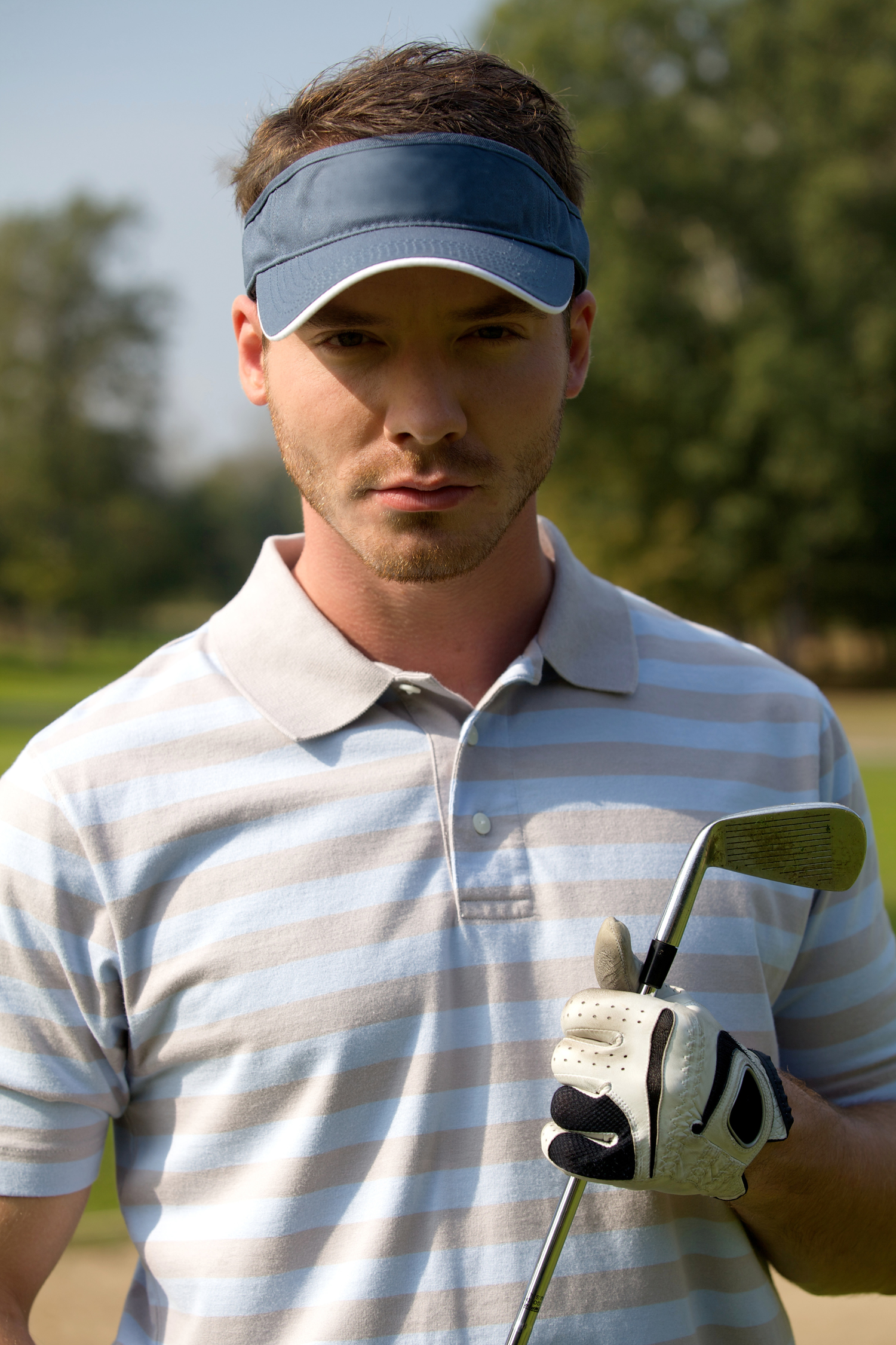 Portrait of young man holding golf stick